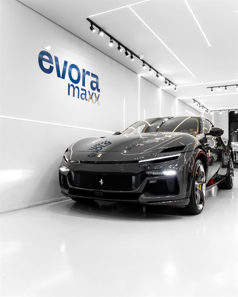 Ferrari Purosangue preta no estúdio da Évora Maxx em Moema, diante da parede com o logotipo